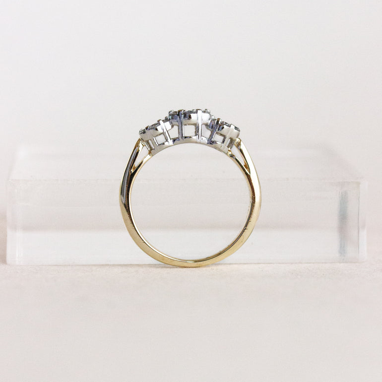 Gold ring with multiple diamonds on a white background