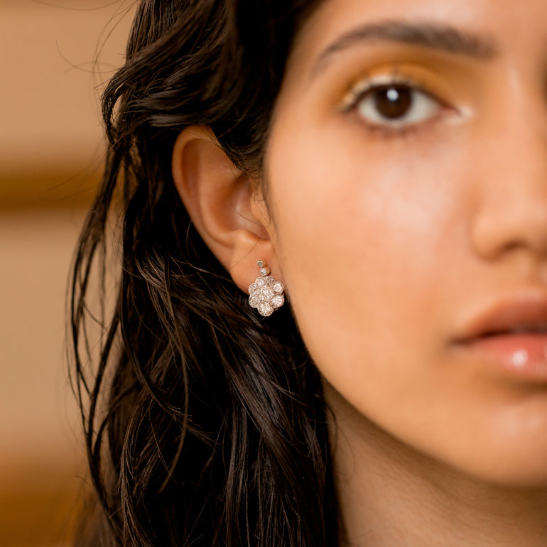 white gold vintage floral diamond studs on model