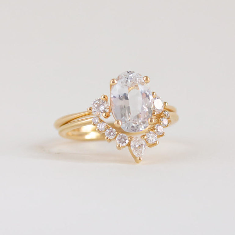 Oval cut white sapphire engagement ring with diamond accents in 14k gold band